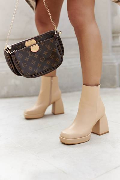 Cizmele izolate ale femeilor, cu călcâie pătrată, mai aproape