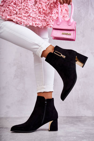 Cizme de piele de căprioară pe o postare cu un decor negru Erine