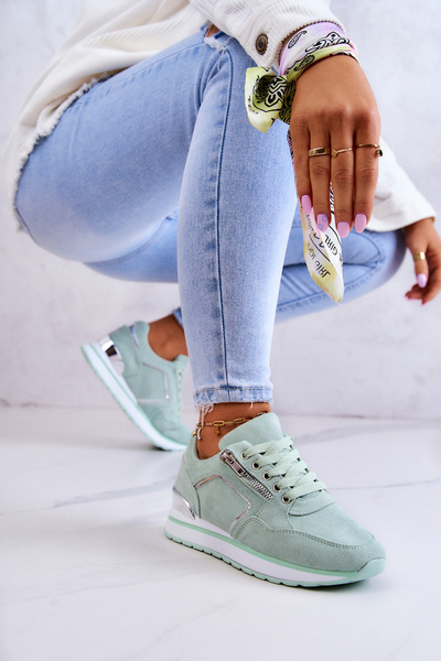 Chaussures de sport en daim sur une plate-forme vert clair au bord de la rivière