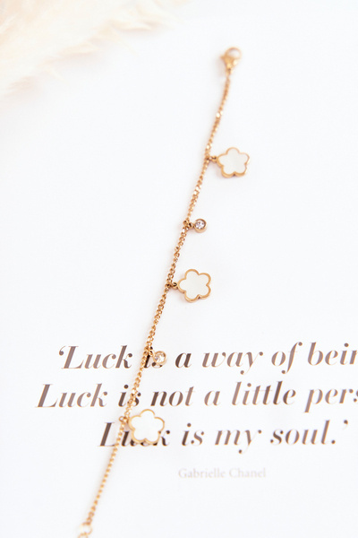 Arany-fehér virágos karkötő láncon